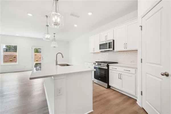 a kitchen with stainless steel appliances granite countertop a sink a stove and a refrigerator