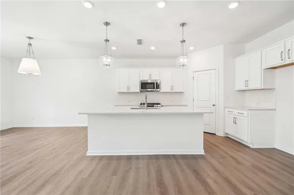 a view of kitchen with granite countertop sink and refrigerator