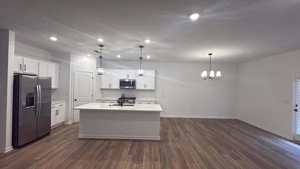 a kitchen with stainless steel appliances a refrigerator sink and wooden floor