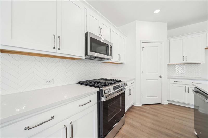 320 Silverleaf Trail Bethlehem, GA 30620 - Photo 9 of 36 a kitchen with stainless steel appliances white cabinets and a stove top oven