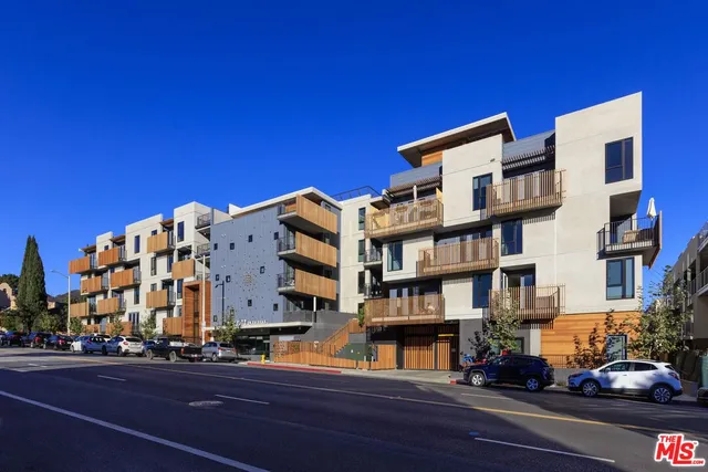a living room with a black white checkered floor with couches chair and a coffee table