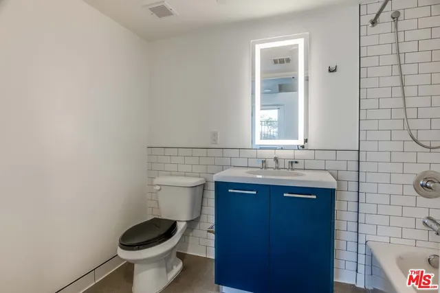 a bathroom with a sink a toilet and mirror