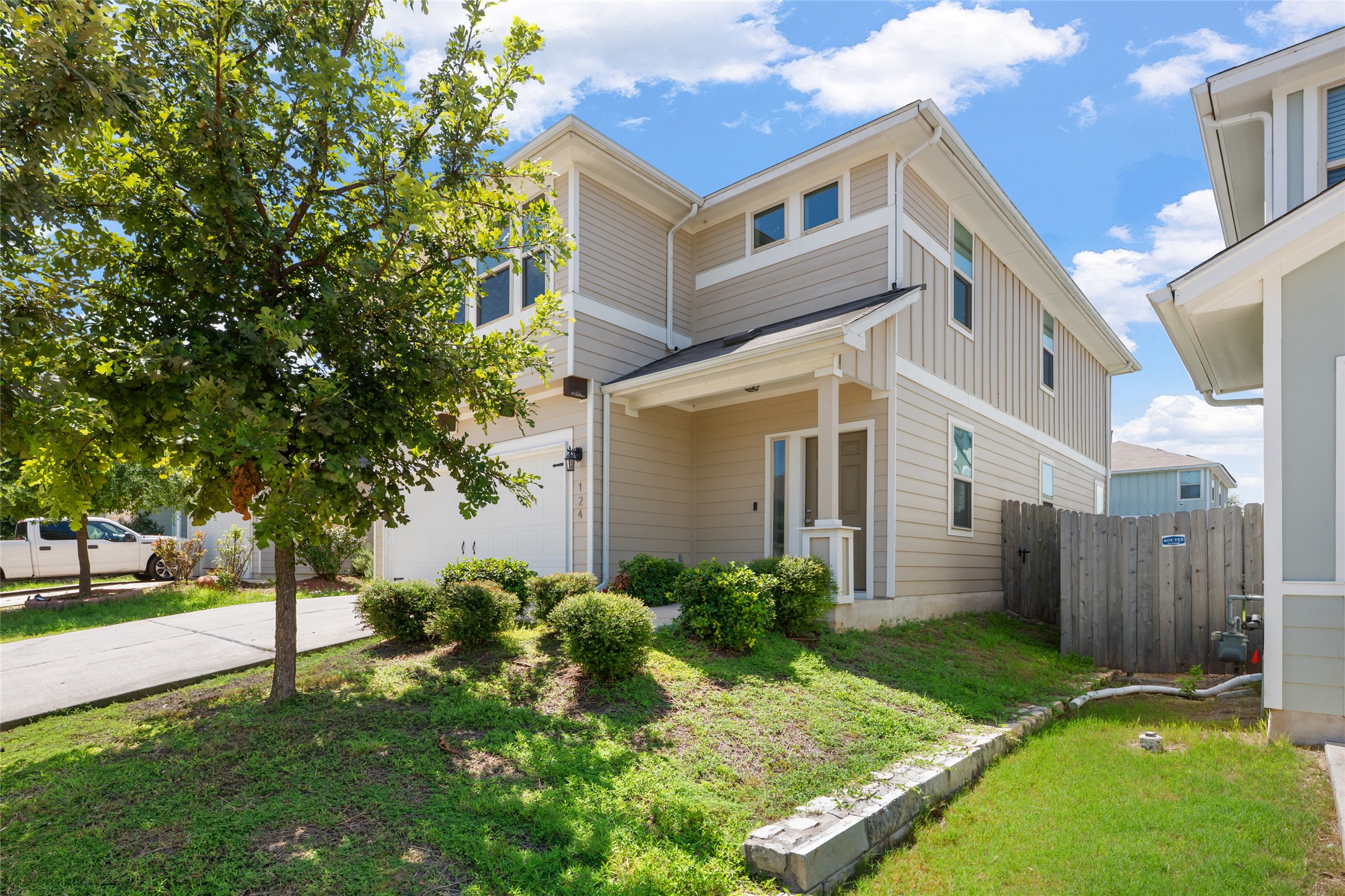 A well-maintained lawn and mature tree enhance the curb appeal of this contemporary residence.