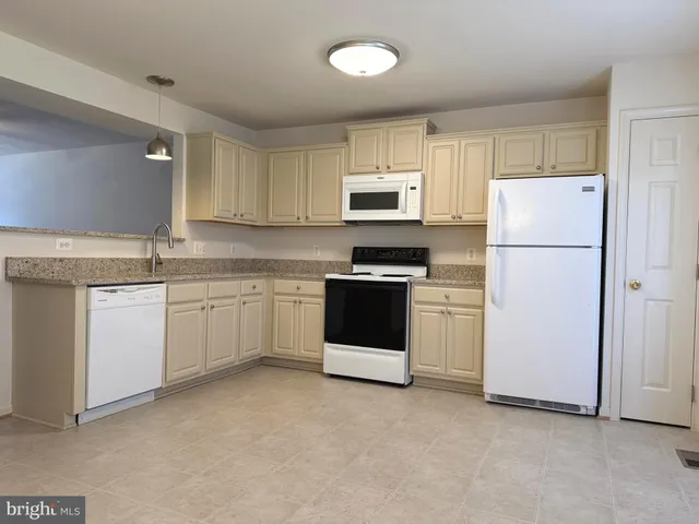 a kitchen with white cabinets and white appliances