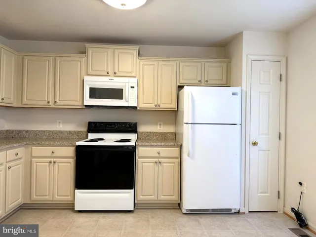 a kitchen with cabinets stainless steel appliances and a counter space