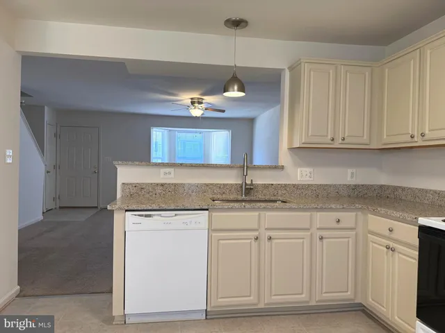 a kitchen with granite countertop white cabinets and a sink