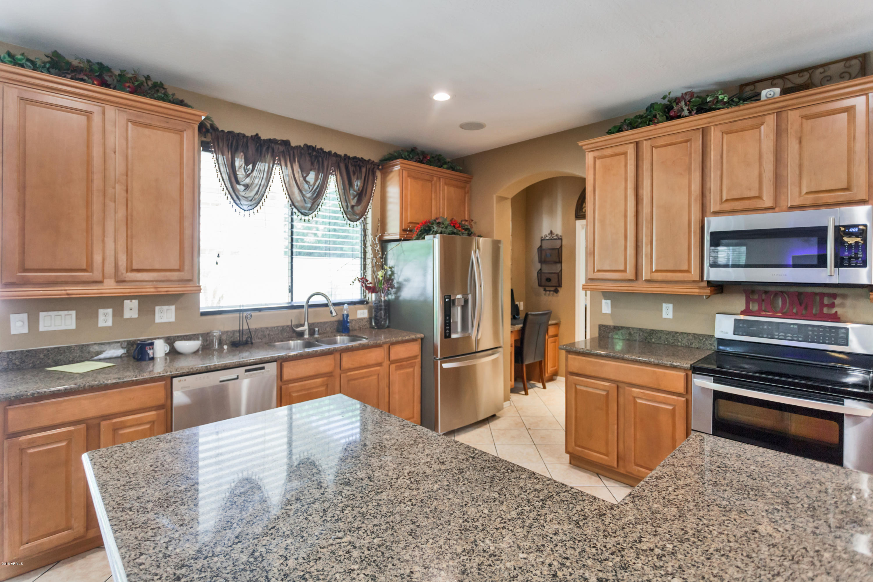 13558 West Calavar Road Surprise, AZ 85379 - Photo 6 of 31 a kitchen with stainless steel appliances granite countertop a refrigerator sink and cabinets
