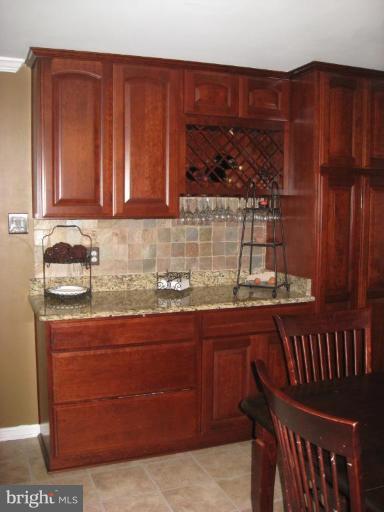 5345 Huntingtown Road Huntingtown, MD 20639 - Photo 3 of 12 a kitchen with stainless steel appliances granite countertop wooden cabinets a stove and a sink
