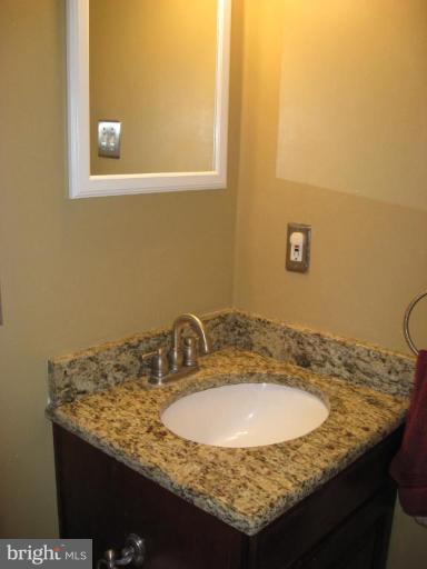 5345 Huntingtown Road Huntingtown, MD 20639 - Photo 4 of 12 a bathroom with a granite countertop sink and a mirror