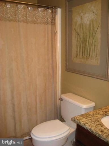 5345 Huntingtown Road Huntingtown, MD 20639 - Photo 8 of 12 a white toilet sitting next to a shower curtain
