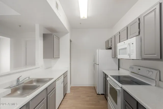 a kitchen with a sink stove top oven and cabinets