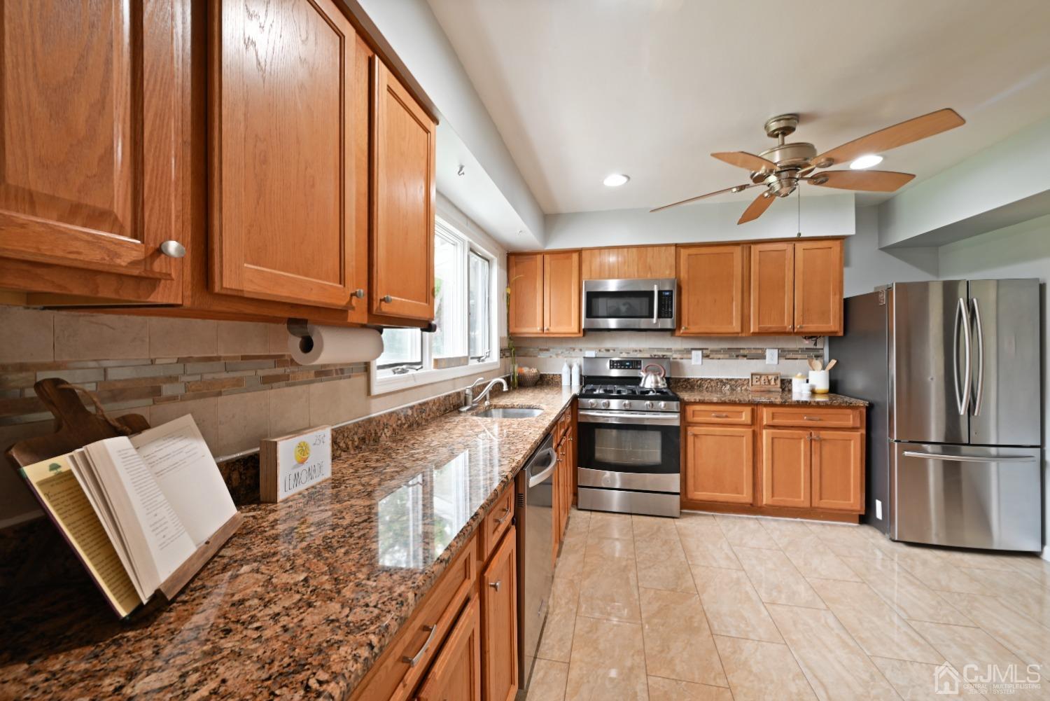 6 Calvin Road Kendall Park, NJ 08824 - Photo 9 of 30 a kitchen with stainless steel appliances granite countertop a refrigerator sink and stove