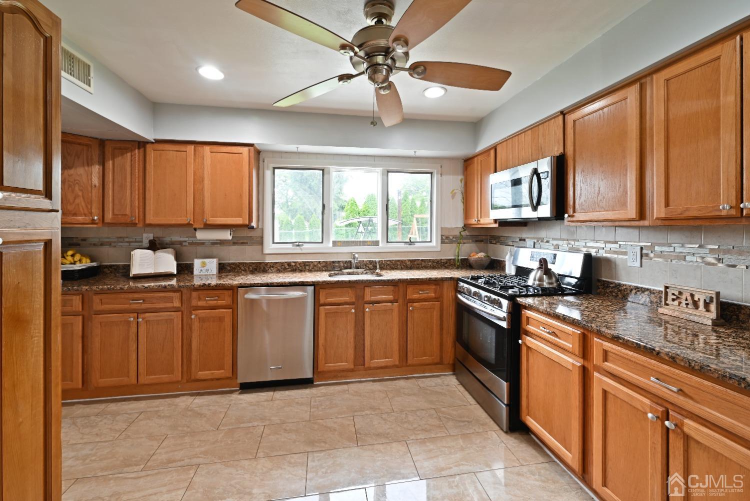 6 Calvin Road Kendall Park, NJ 08824 - Photo 10 of 30 a kitchen with stainless steel appliances granite countertop a stove sink and cabinets