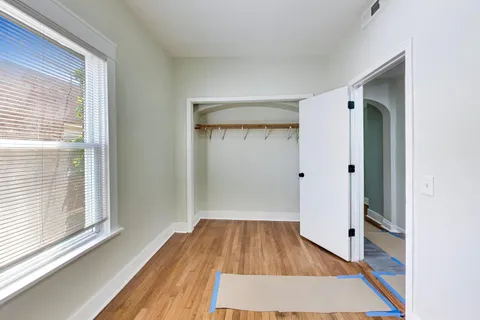 a view of a room with wooden floor and a window