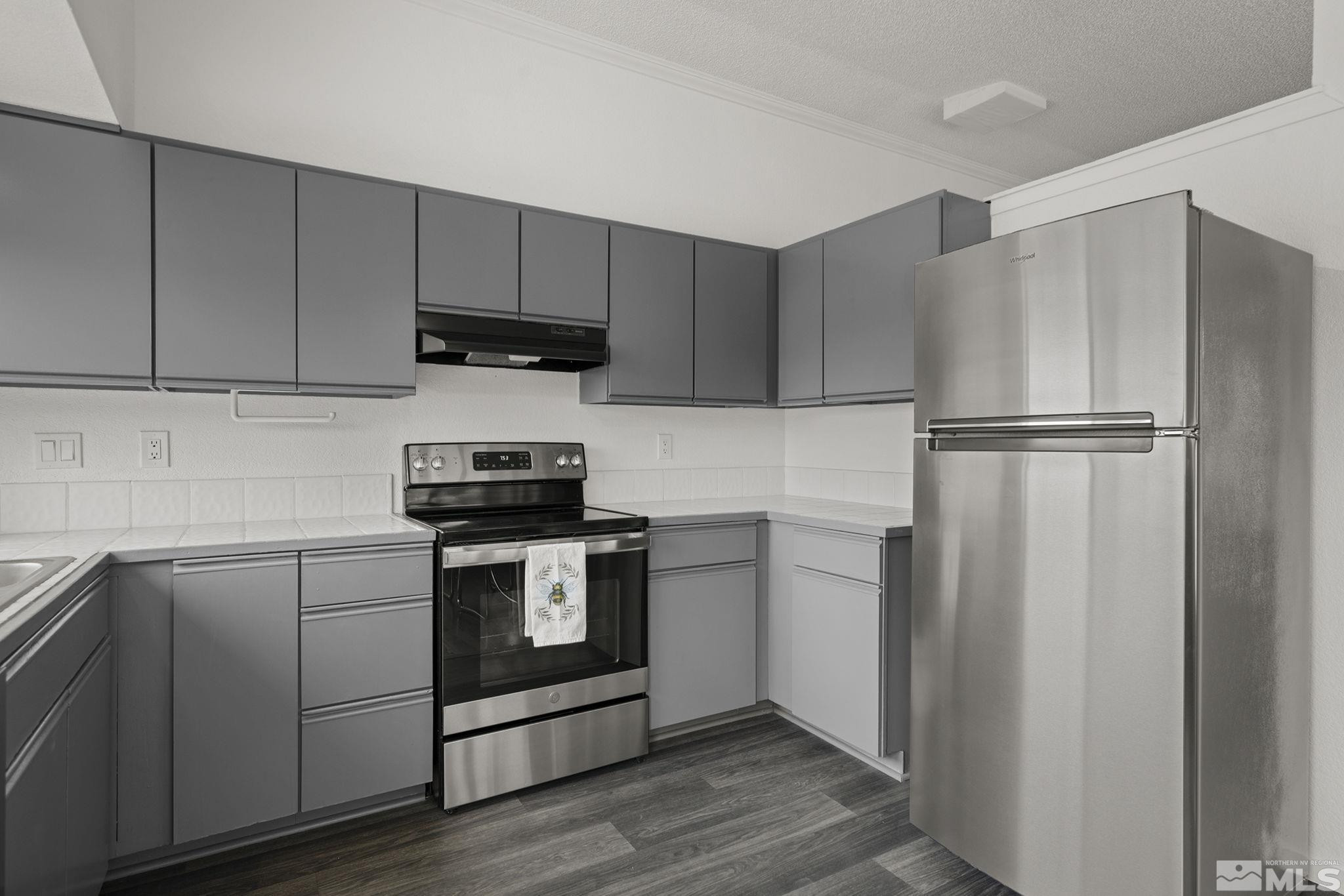 6885 Flower Street Reno, NV 89506 - Photo 9 of 21 a kitchen with a stove refrigerator and microwave