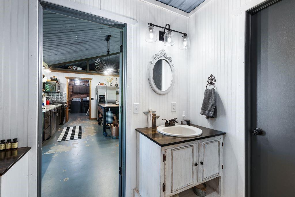 50 County Road Blossom, TX 75416 - Photo 27 of 40 a bathroom with a sink a mirror and shower