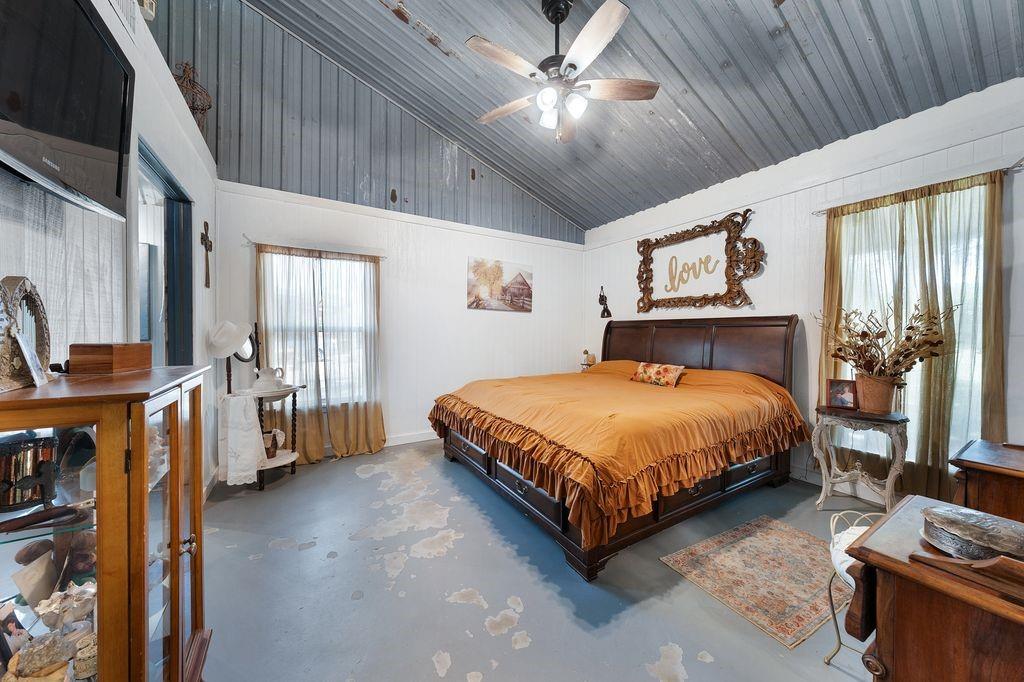 50 County Road Blossom, TX 75416 - Photo 29 of 40 a bedroom with a large bed and a chandelier