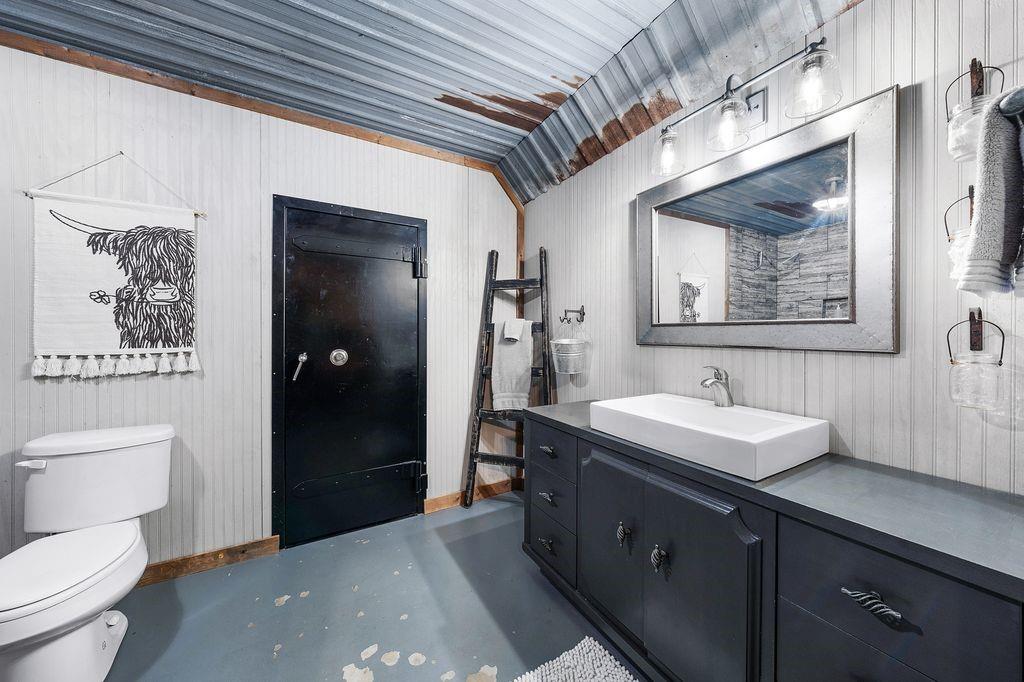 50 County Road Blossom, TX 75416 - Photo 31 of 40 a spacious bathroom with a toilet a sink and mirror