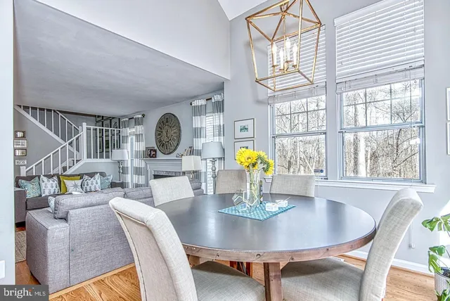 a dining room with furniture a chandelier and wooden floor