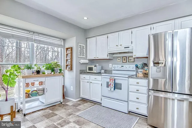 a kitchen with stainless steel appliances a refrigerator sink and cabinets