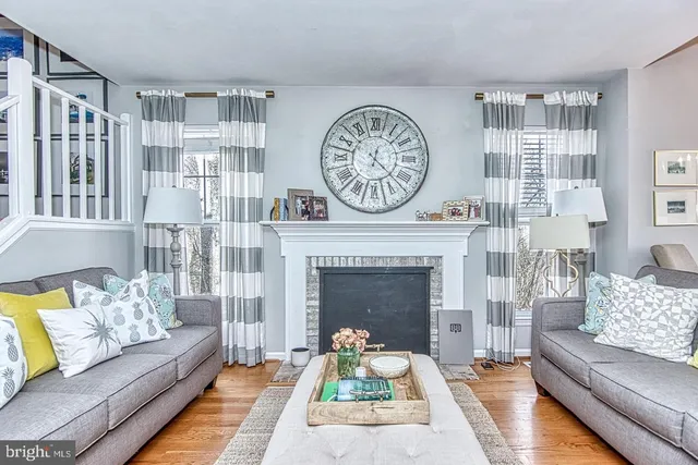 a living room with furniture a clock and a fireplace