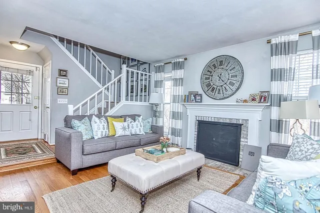 a living room with furniture and a dining table with wooden floor