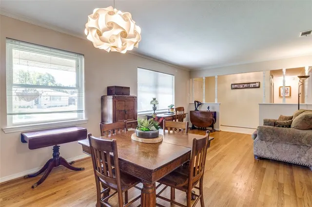 a view of a dining room with furniture a chandelier and wooden floor