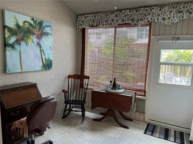 a view of a room with wooden floor chandelier and windows