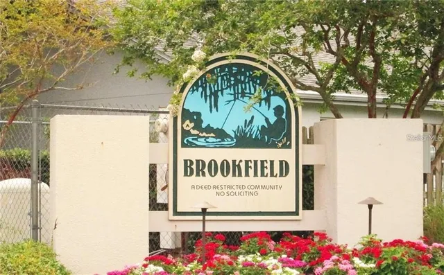 a view of an empty room with wooden floor and windows
