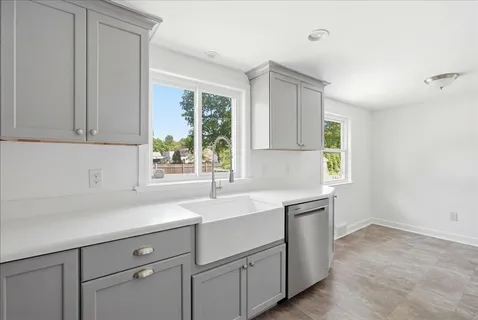 a kitchen with a sink cabinets appliances and a window