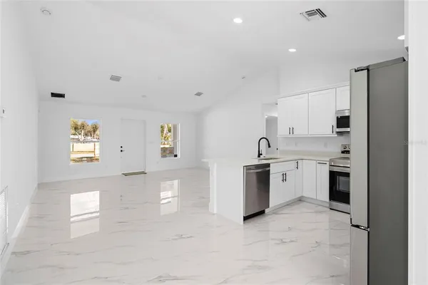 a kitchen with a refrigerator a stove and a cabinets