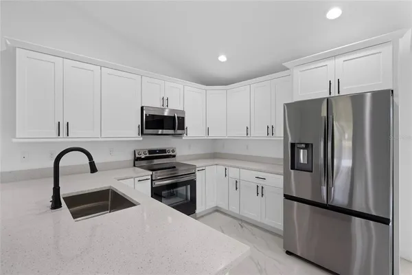a kitchen with stainless steel appliances a refrigerator and microwave