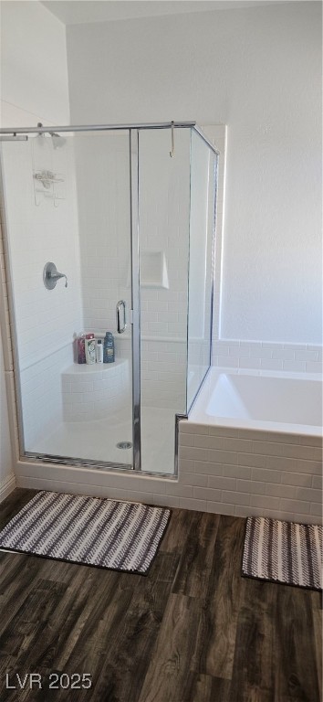 7050 Fossil Rim Street North Las Vegas, NV 89084 - Photo 12 of 19 Full bath featuring dark wood finished floors, a stall shower, and a bath