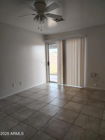 a view of an empty room and chandelier fan