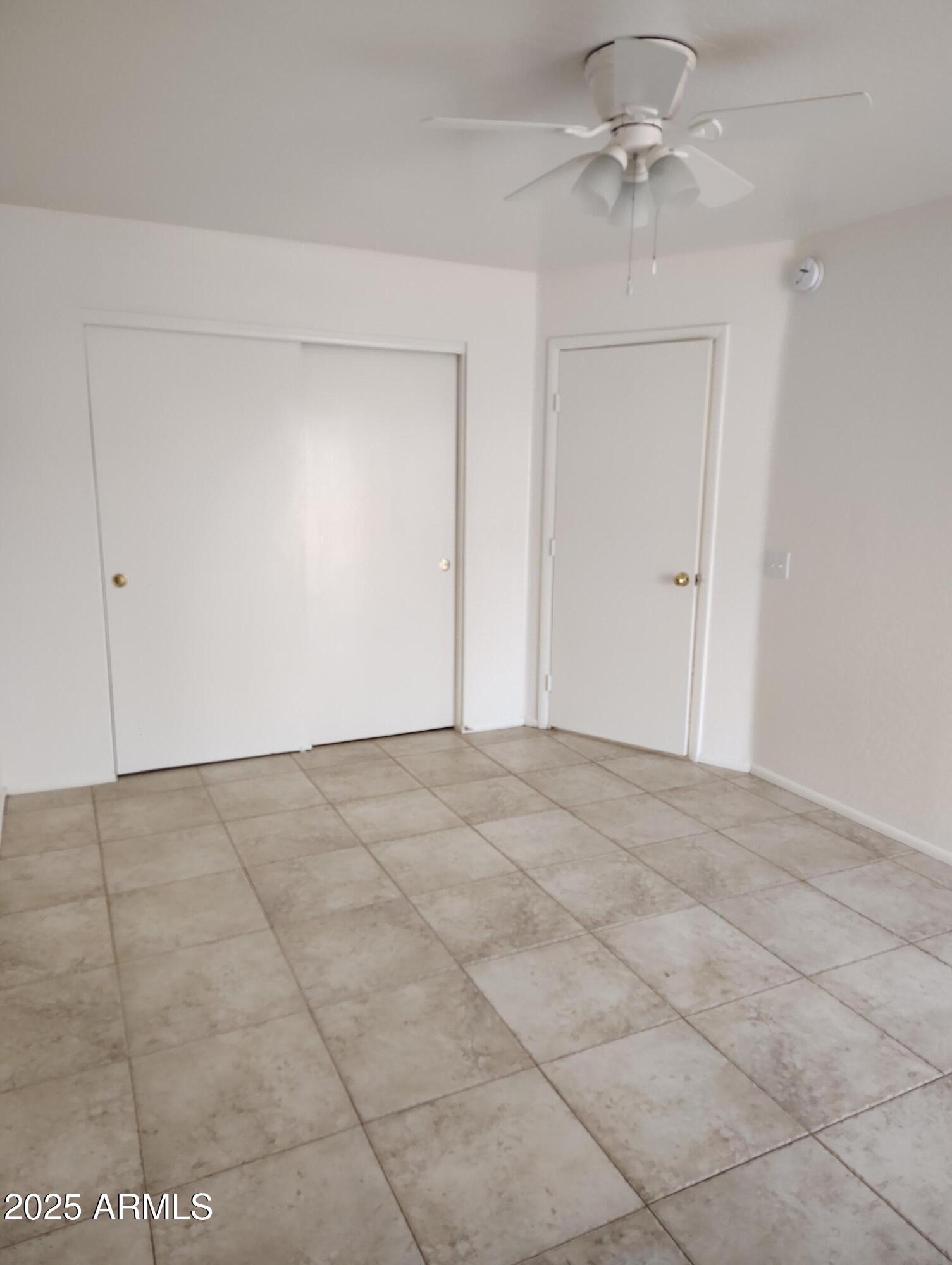 1471 East 27th Avenue, Unit 2 Apache Junction, AZ 85119 - Photo 14 of 16 a view of an empty room and chandelier fan