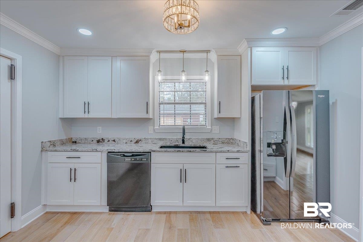440 Dykes Road Mobile, AL 36608 - Photo 15 of 49 Kitchen featuring visible vents, dishwasher, stainless steel fridge, white cabinetry, and a sink
