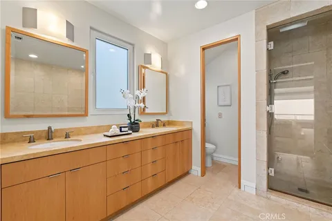 a bathroom with a granite countertop toilet sink and mirror