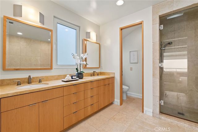 a bathroom with a granite countertop toilet sink and mirror