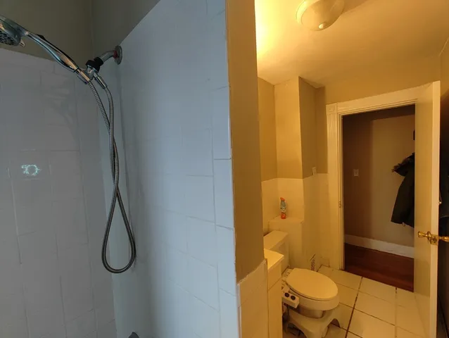 a bathroom with a granite countertop shower and a toilet