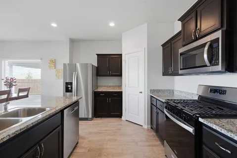 a kitchen with stainless steel appliances granite countertop a refrigerator stove and sink