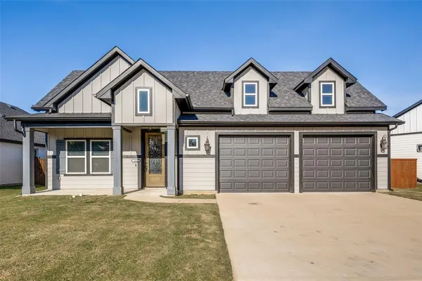 a view of a house with a garage and yard