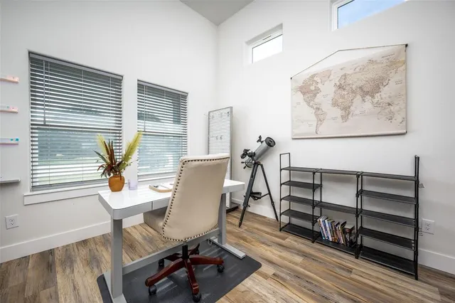a view of a workspace with furniture and a window