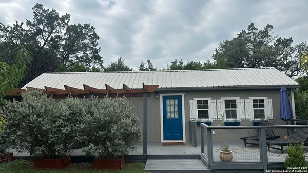 a view of a house with wooden deck and a garden