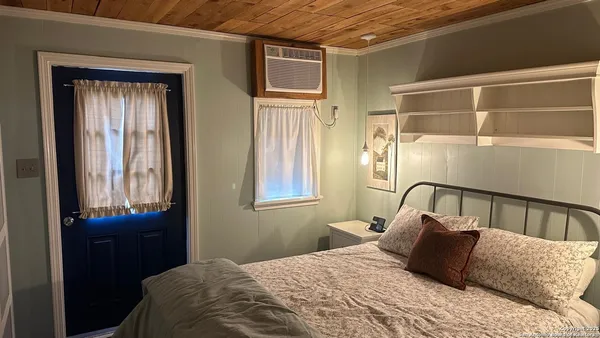 a bedroom with a bed next to a window