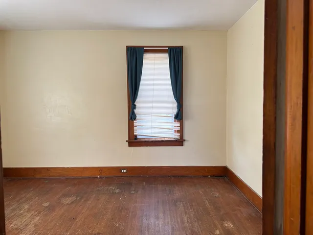 a view of a small space with wooden floor and a window
