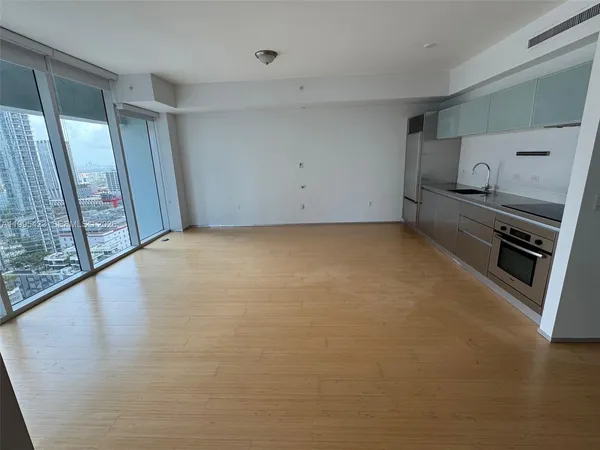 a view of a kitchen with fridge wooden floor and window