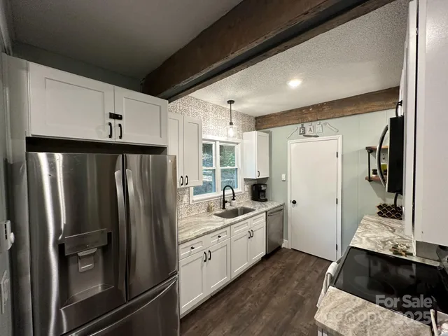 a kitchen with stainless steel appliances a refrigerator sink and cabinets