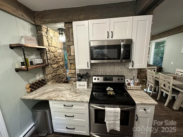 a kitchen with stainless steel appliances a stove a sink and a microwave