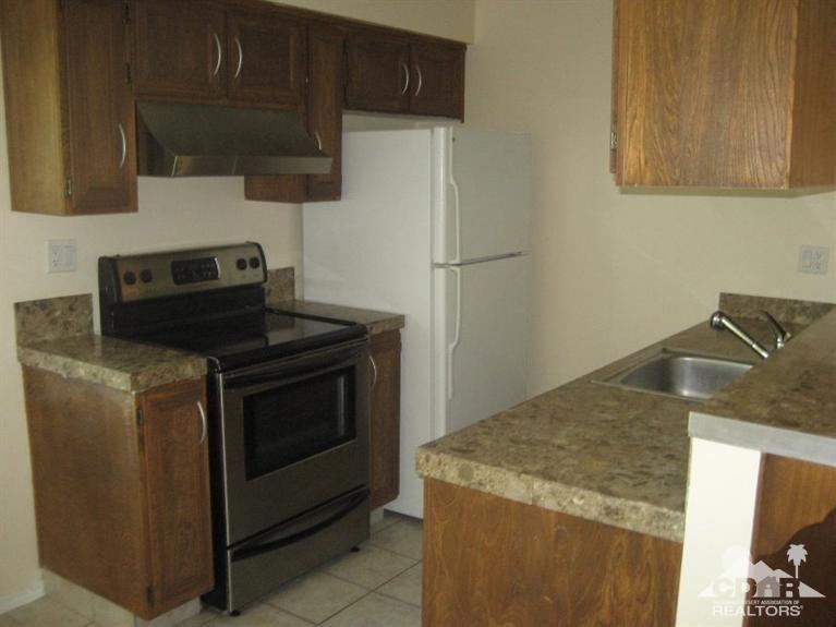 72711 Eagle Road, Unit 4 Palm Desert, CA 92260 - Photo 1 of 29 a kitchen with a stove and a microwave
