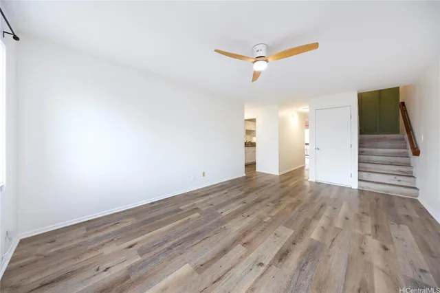 a view of a room with wooden floor and ceiling fan